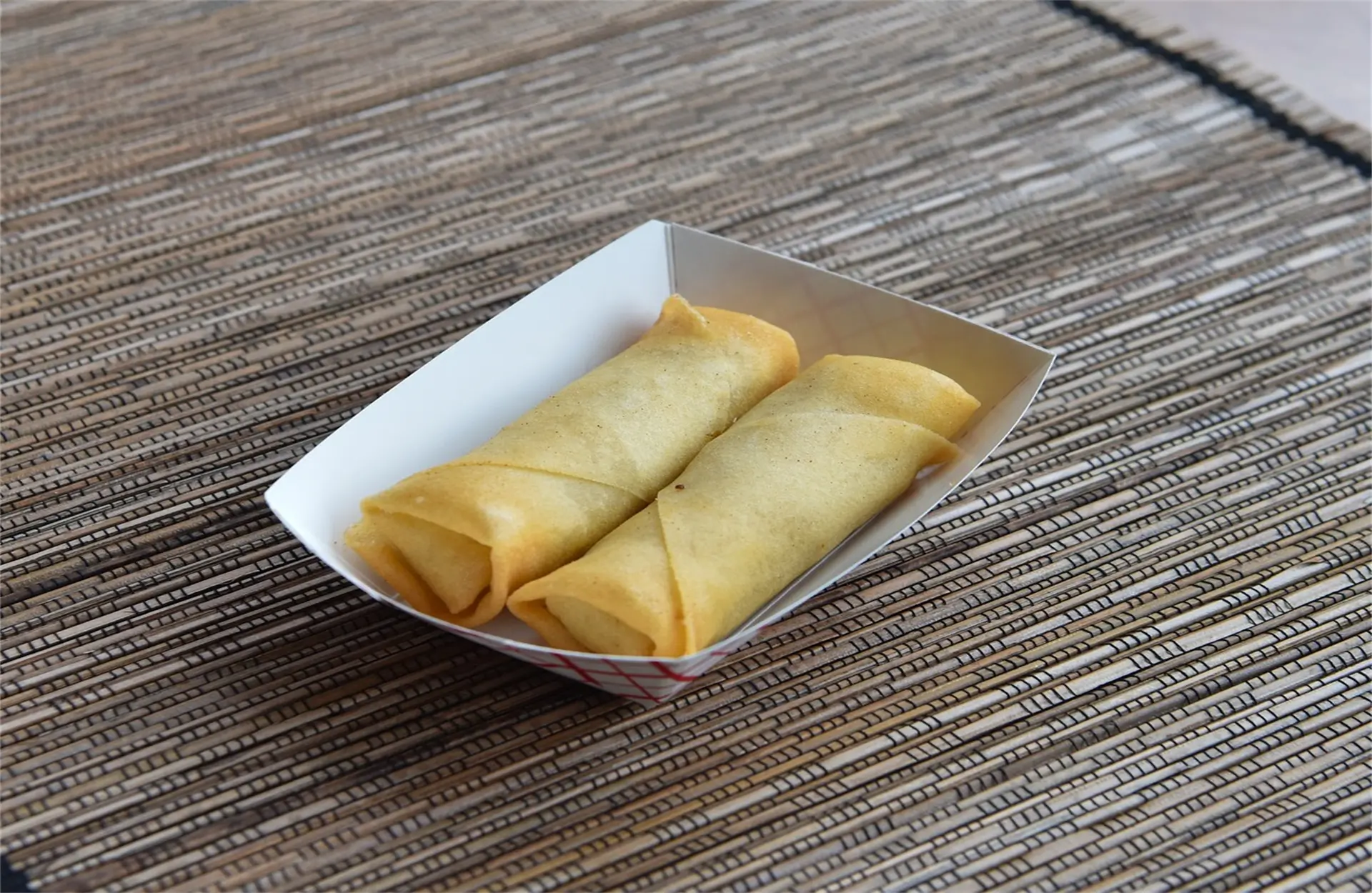 Wah-Wah-Kitchen-Inc-Chinese-Restaurant-Veggie-Egg-Rolls-Amityville Two crispy vegetable egg rolls in a small box at Wah Wah Kitchen Inc, a Chinese restaurant in Amityville.